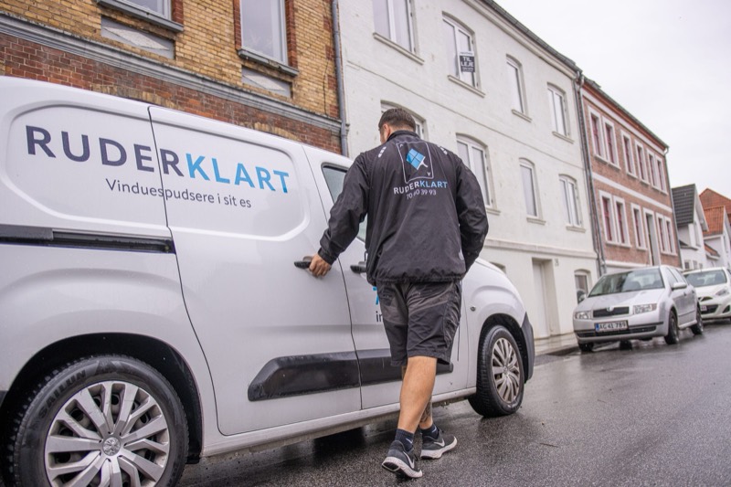 Vinduespudser ved Ruderklarts varebil på en bygade
